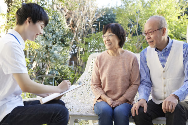 職員と入居者が屋外で書類確認や相談をしている様子